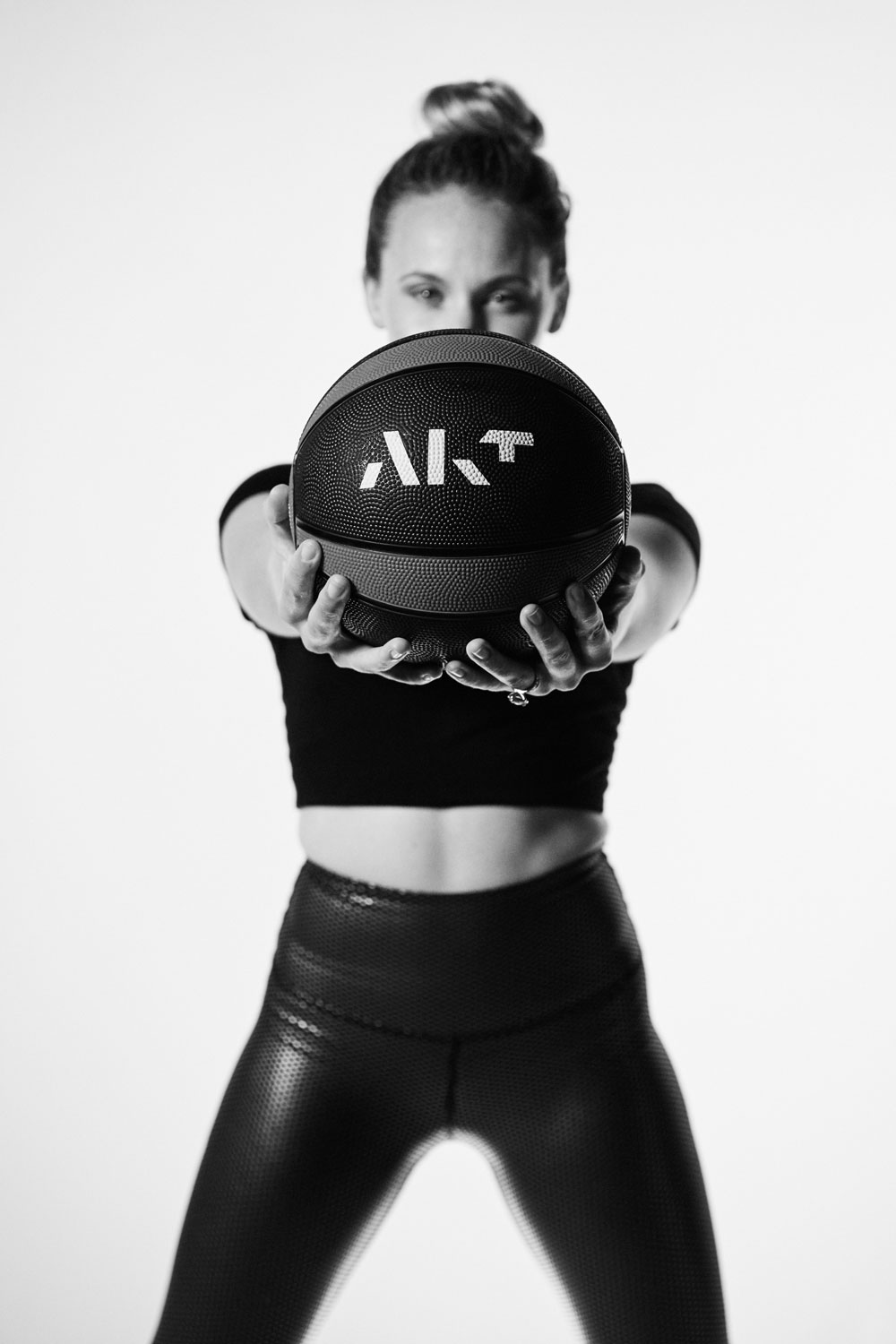 Person holding a medicine ball with AKT logo