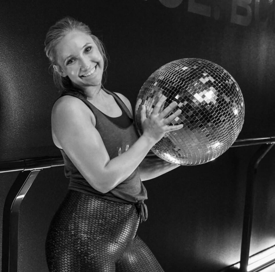 Person holding a disco ball and posing for the camera